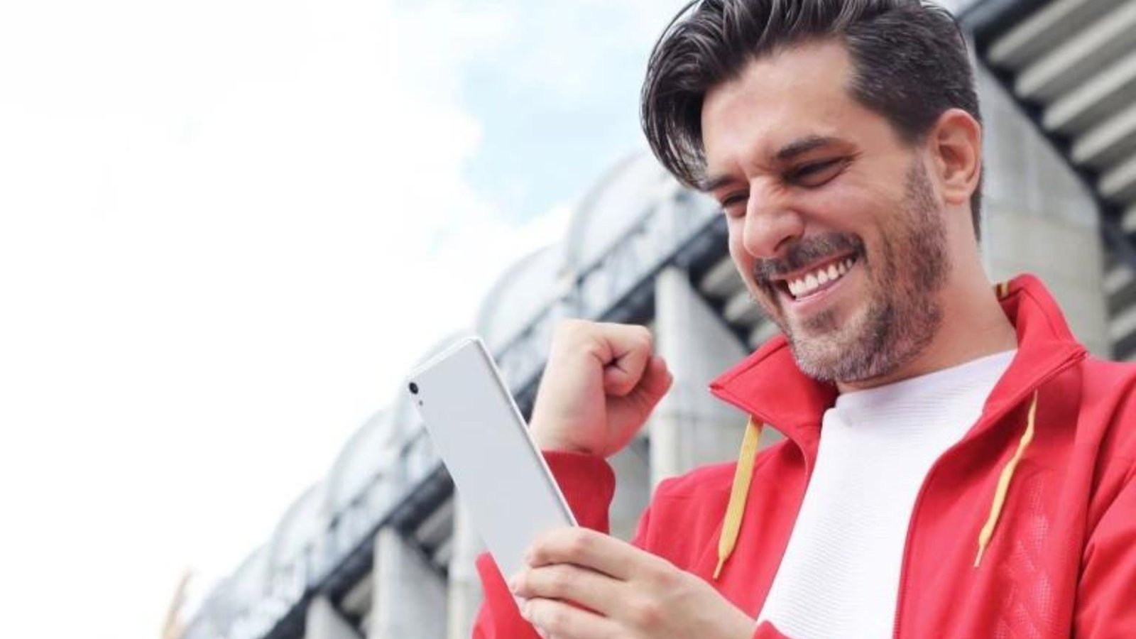 A Man Wearing a Red Jacket and White Shirt Holding a Phone 